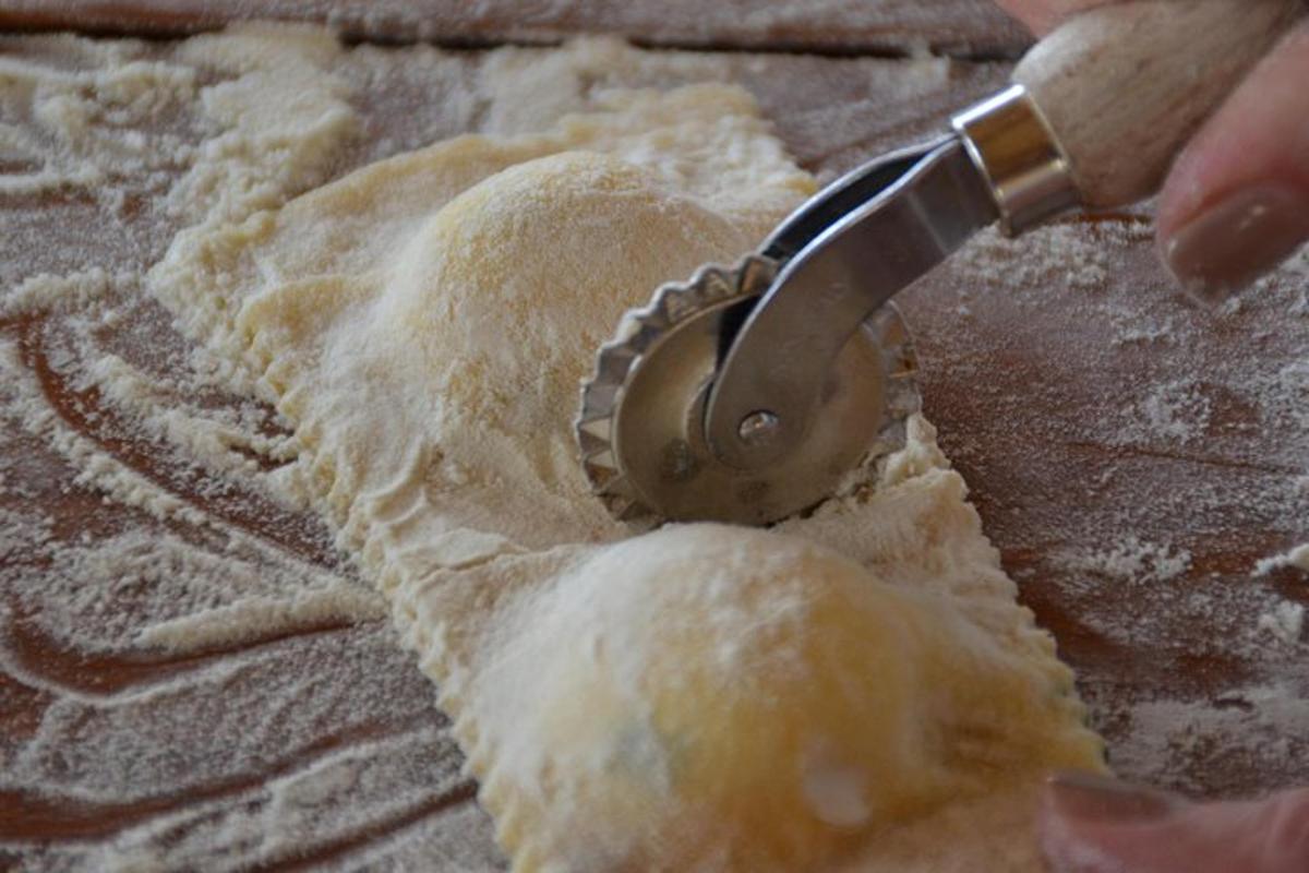 osoba používající vykrajovátko na těsto k vykrojení kusu těsta