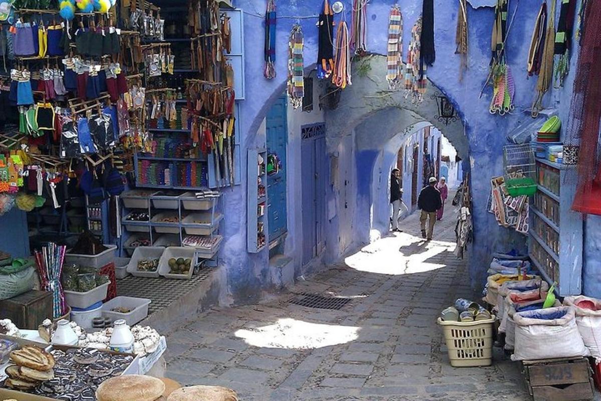 lorong dengan bangunan biru dengan orang ramai berjalan melaluinya