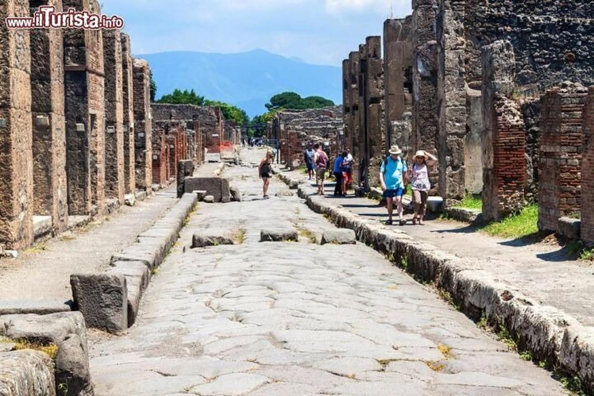 un gruppo di persone che cammina lungo una strada tra le rovine