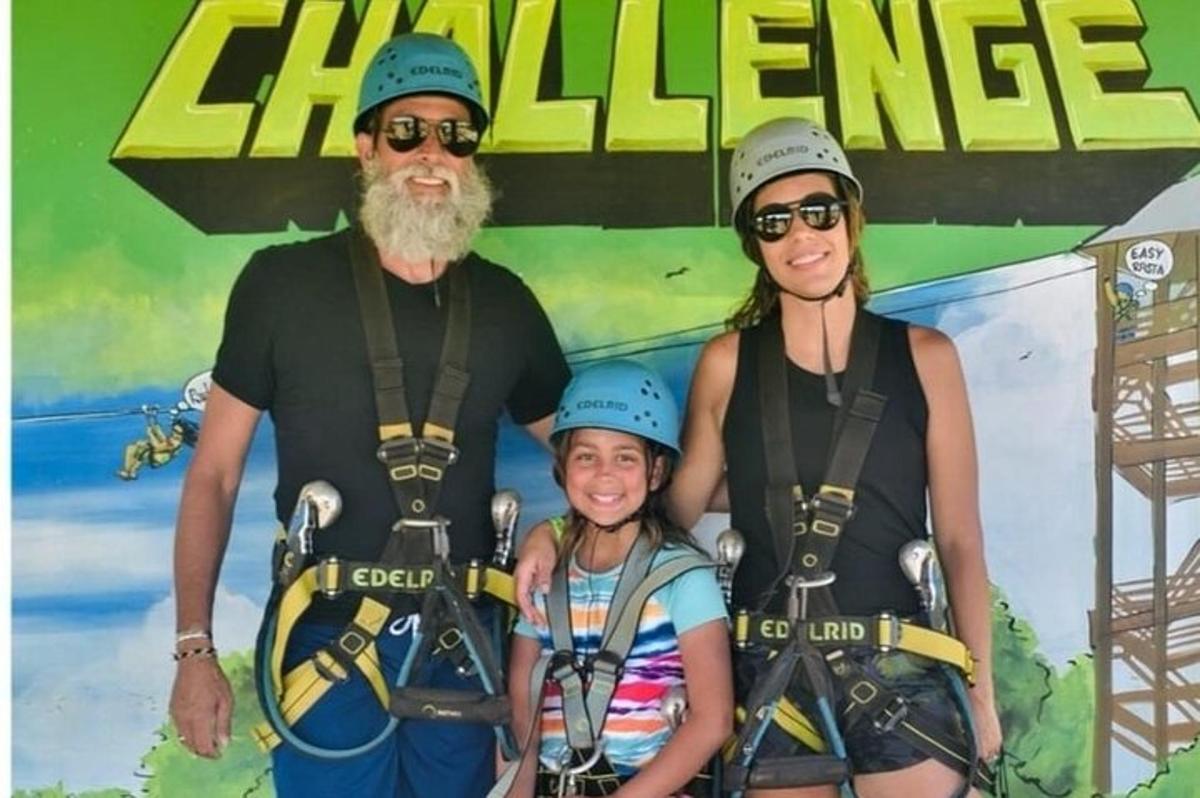 родина позує для фотографії перед вивіскою