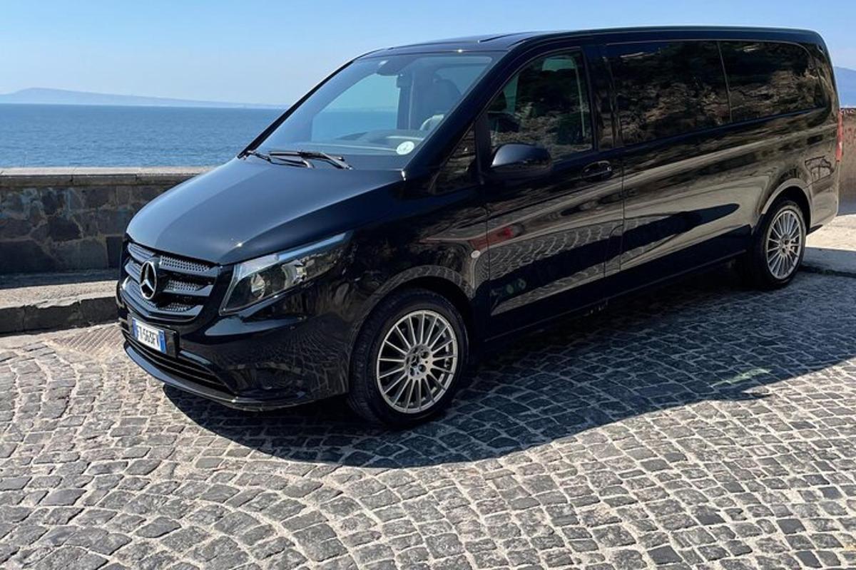 črn kombi parkiran na tlakovani ulici