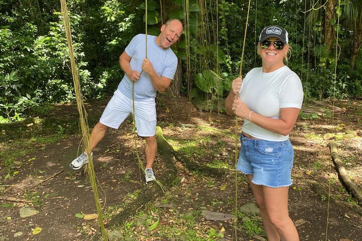a man and a woman standing on a rope swing
