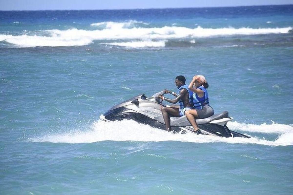 dve osebi, ki se vozita na vodnem skuterju v oceanu