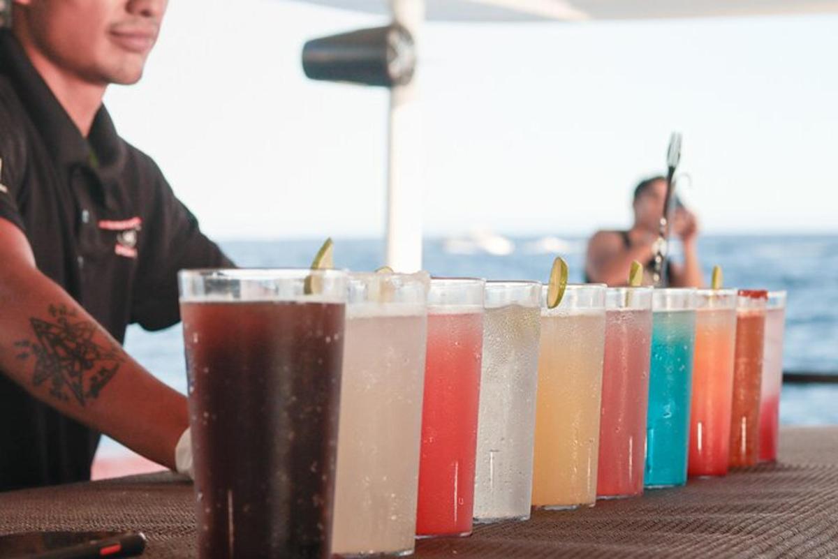 seorang lelaki duduk di meja dengan deretan minuman