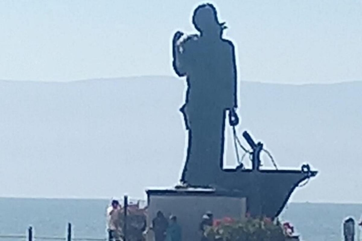 una statua di un uomo in piedi di fronte all'oceano