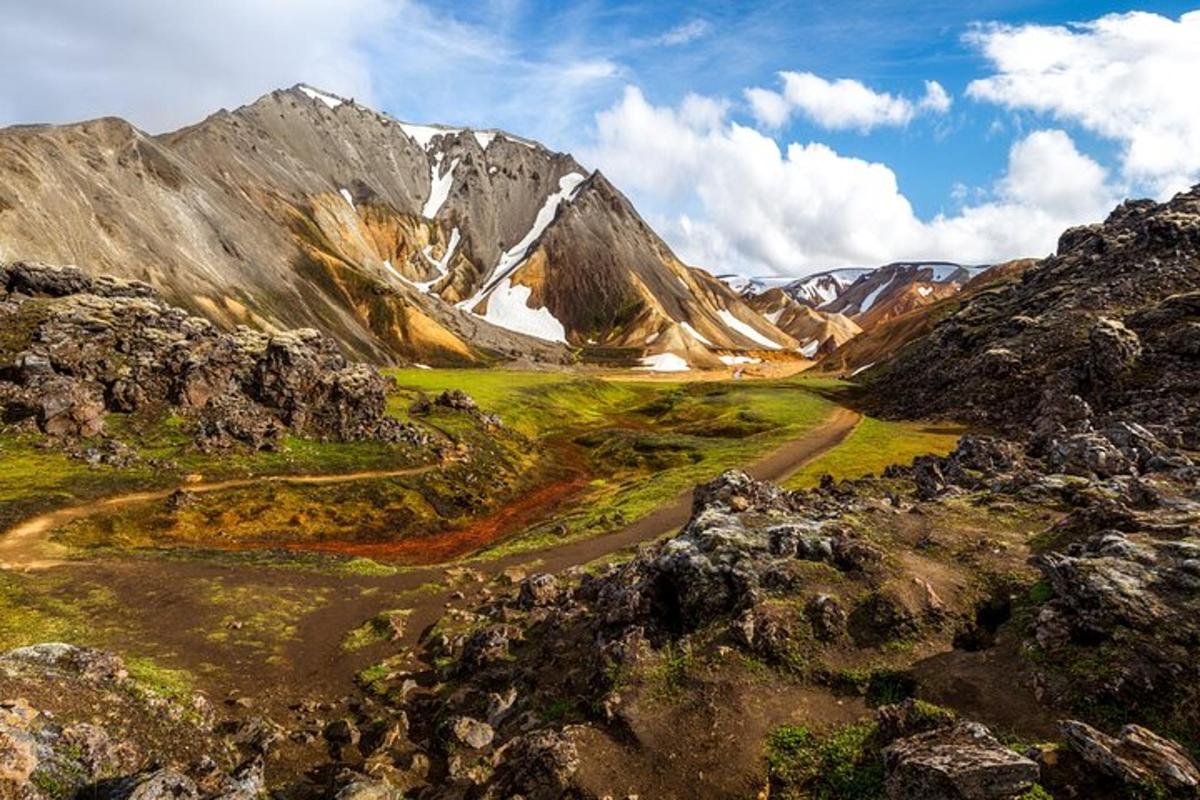 a mountain range with a dirt road in the foreground