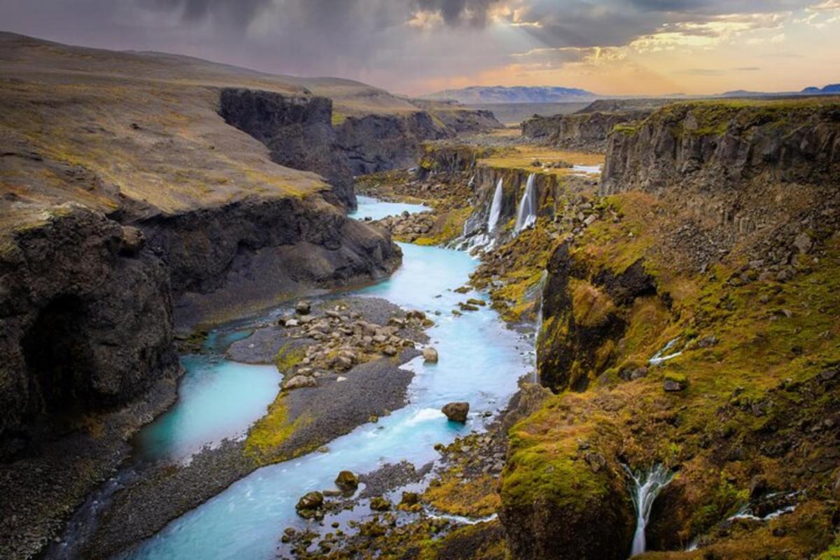 an aerial view of a waterfall in a canyon