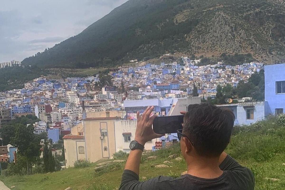 muž fotografující město fotoaparátem