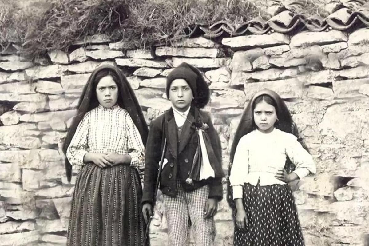 mustvalge foto kolmest tüdrukust kivimüüri ees