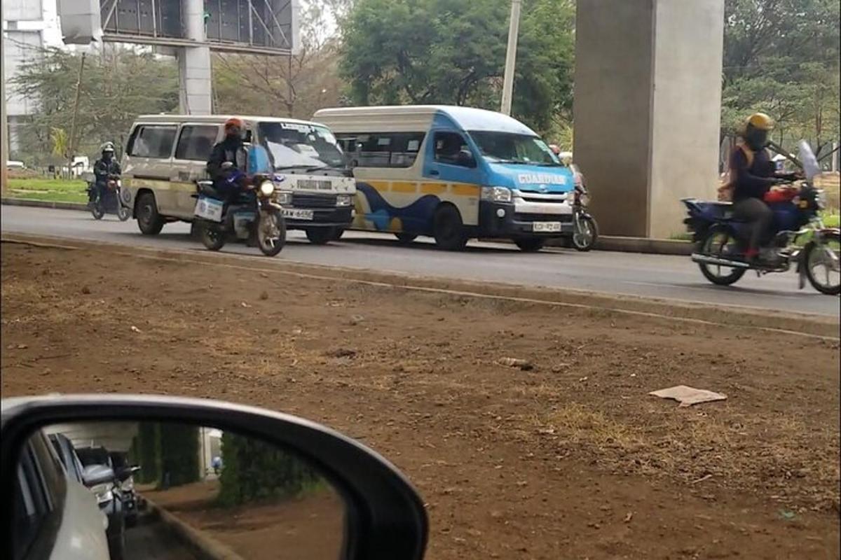 a group of people riding motorcycles on a road with vehicles