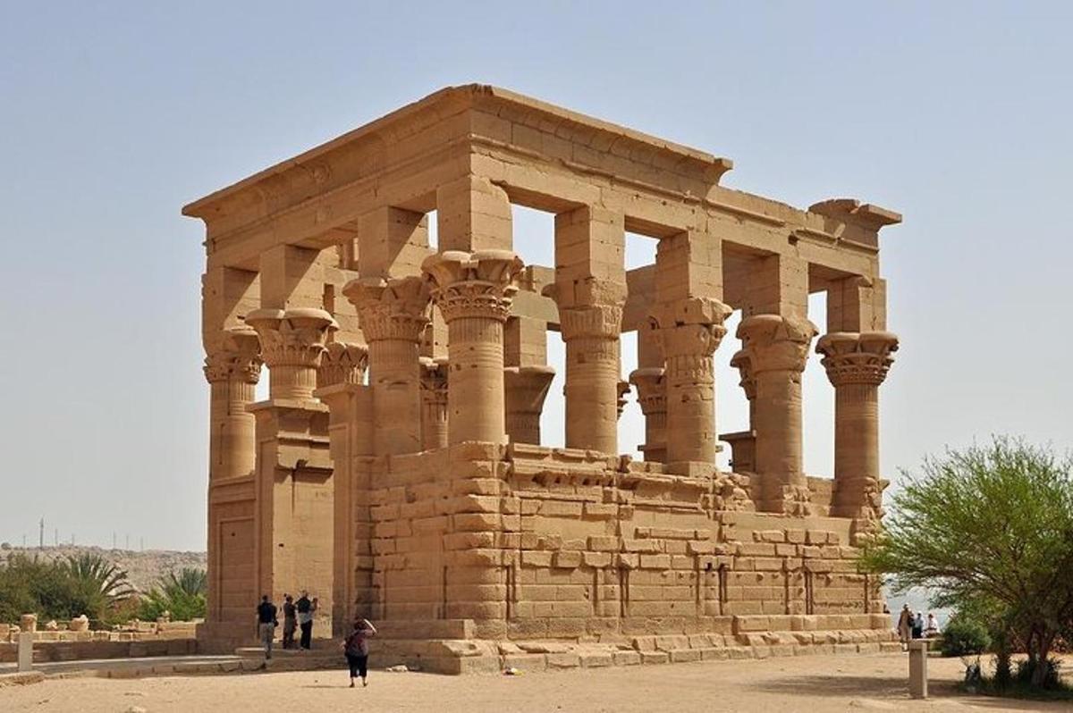 an ancient building with people standing in front of it