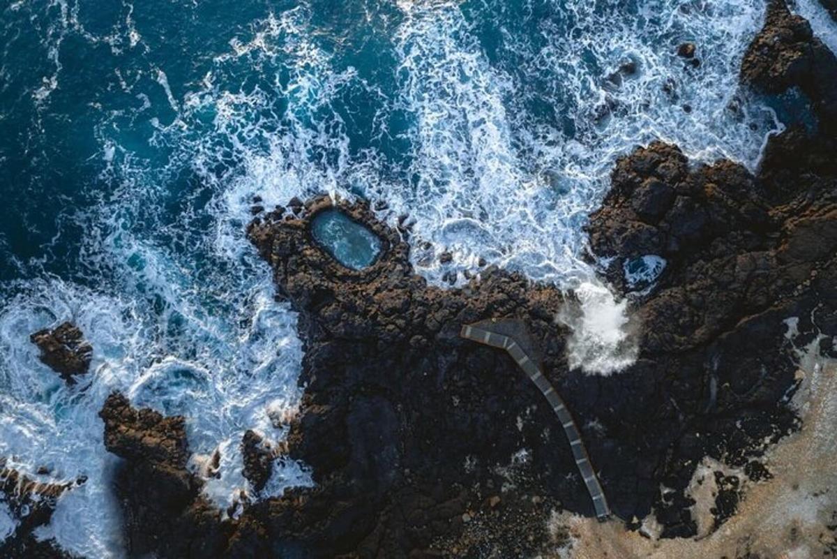 Una vista aérea de una playa rocosa con el océano.