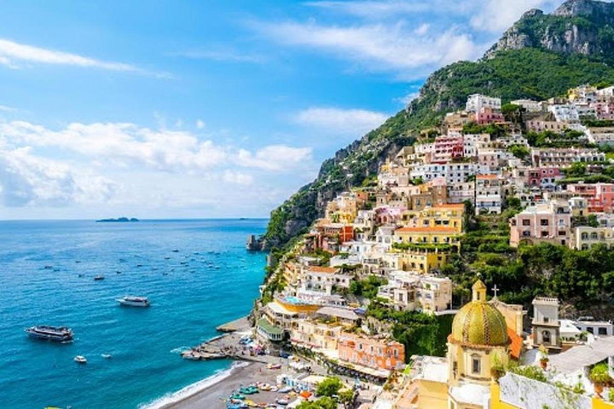 a town on a hill next to the ocean