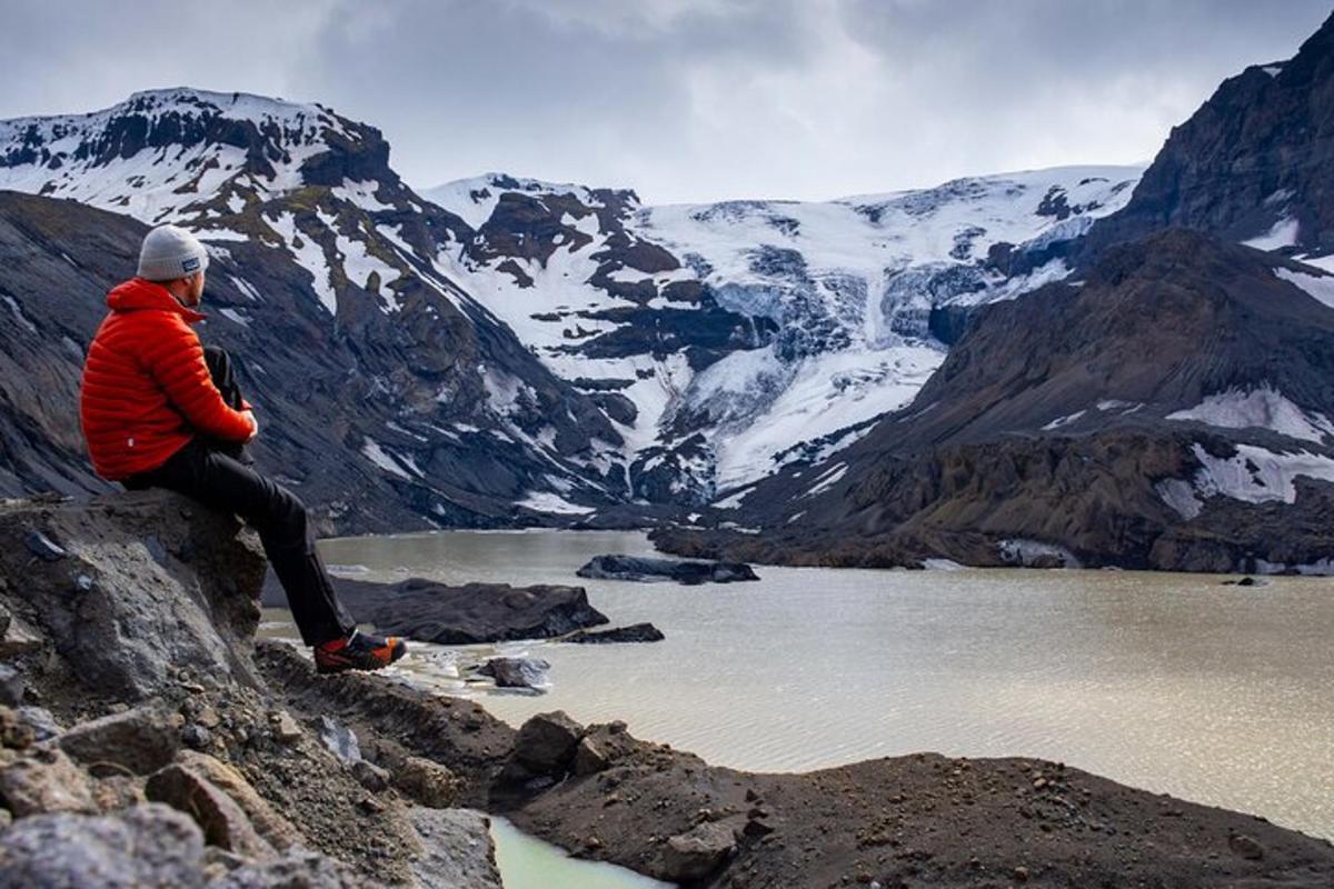 una persona seduta in cima a una montagna che domina un lago