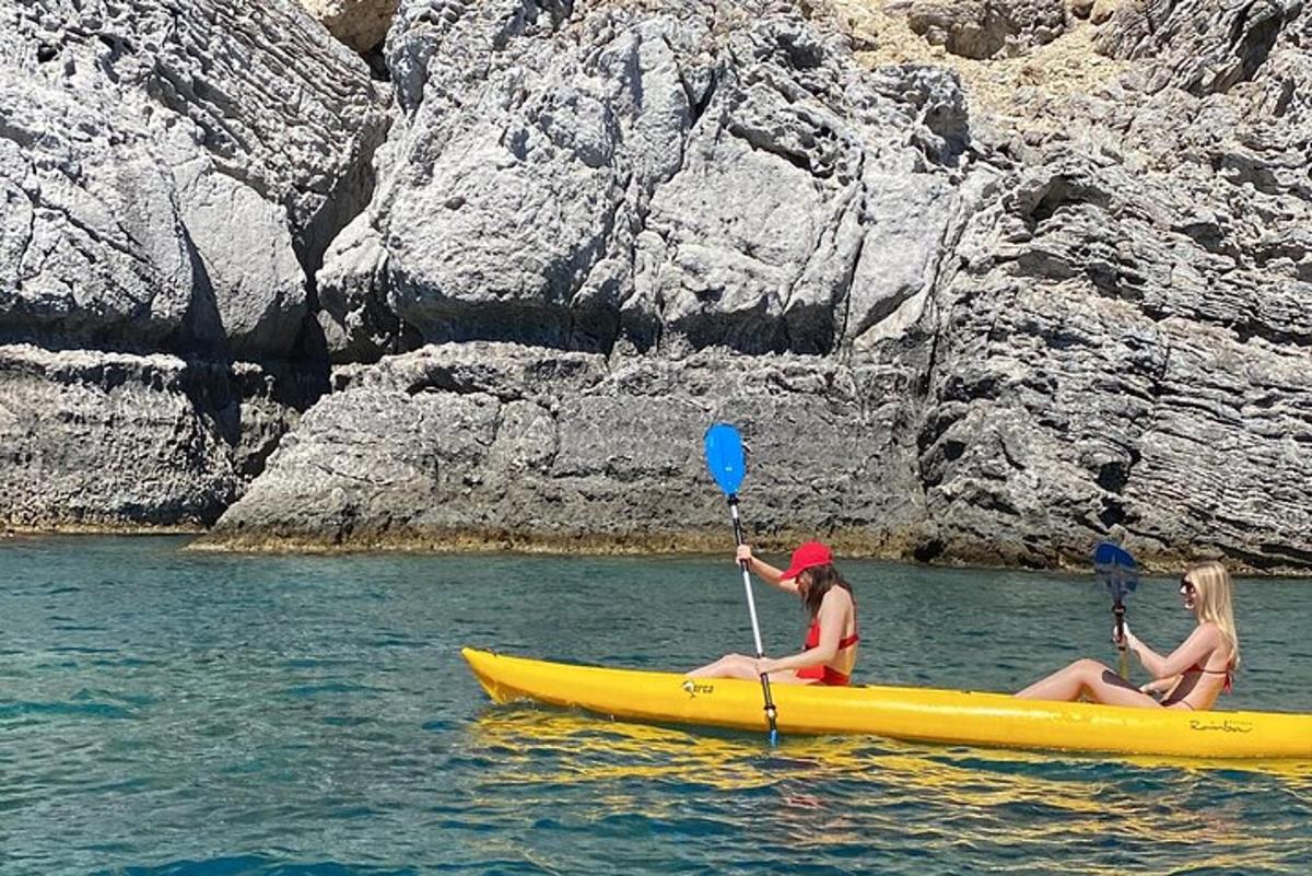 Δύο γυναίκες κάθονται σε ένα κίτρινο καγιάκ στο νερό