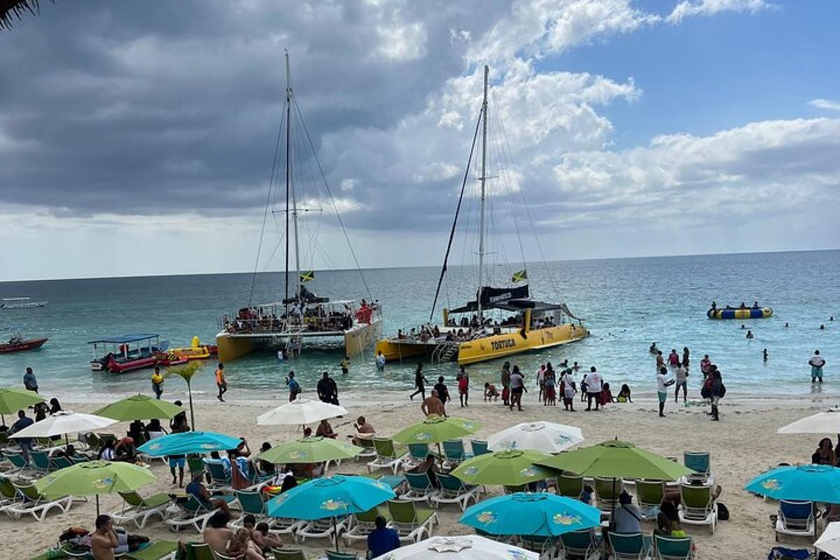 un gruppo di persone su una spiaggia con barche in acqua