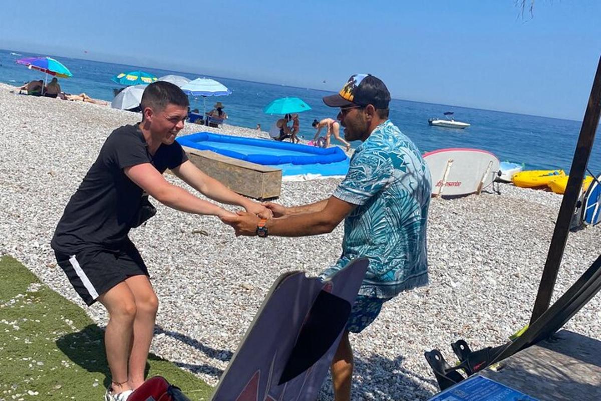 dua lelaki sedang berjabat tangan di pantai