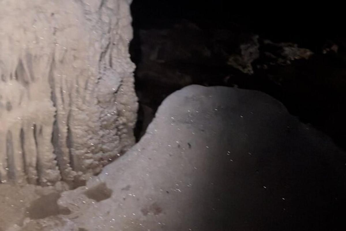 a pile of snow on the floor of a cave
