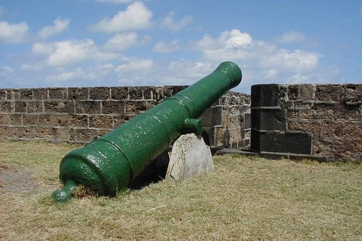 a green pipe leaning against a brick wall