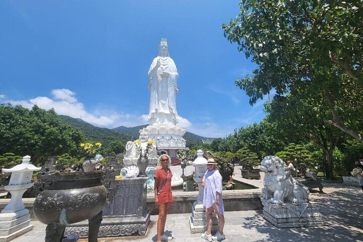 um homem e uma mulher em pé em frente a uma estátua