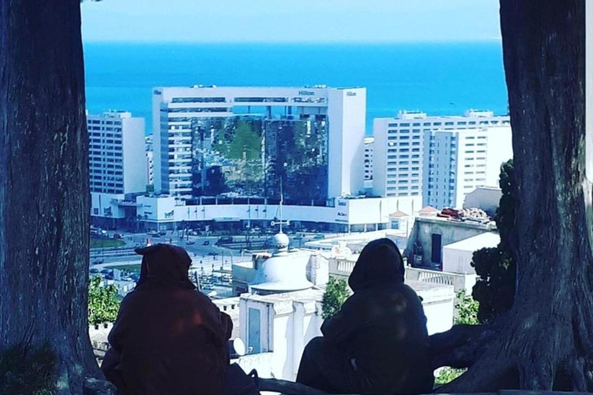 deux personnes assises sur un rebord regardant une ville