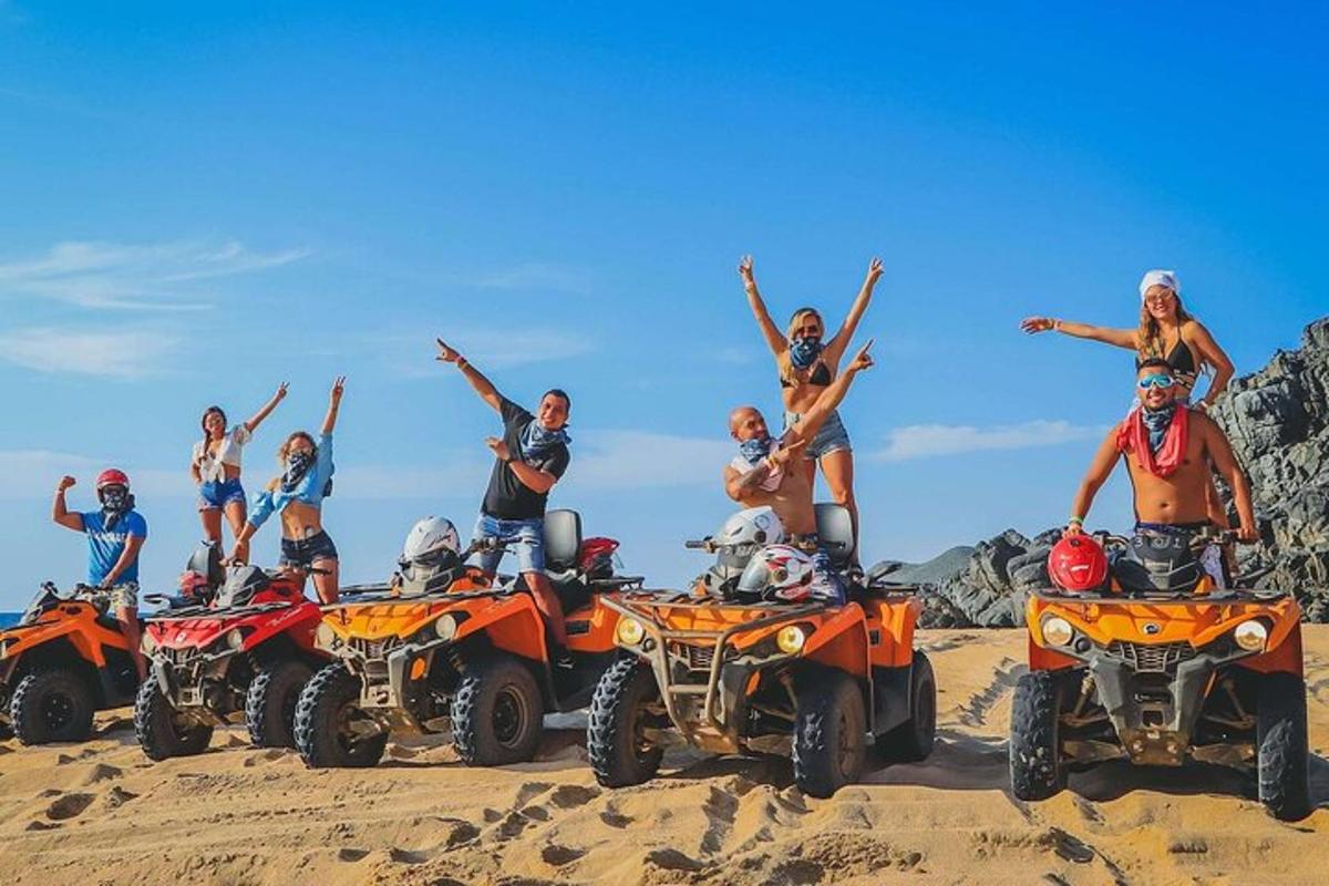a group of people standing on atvs in the sand