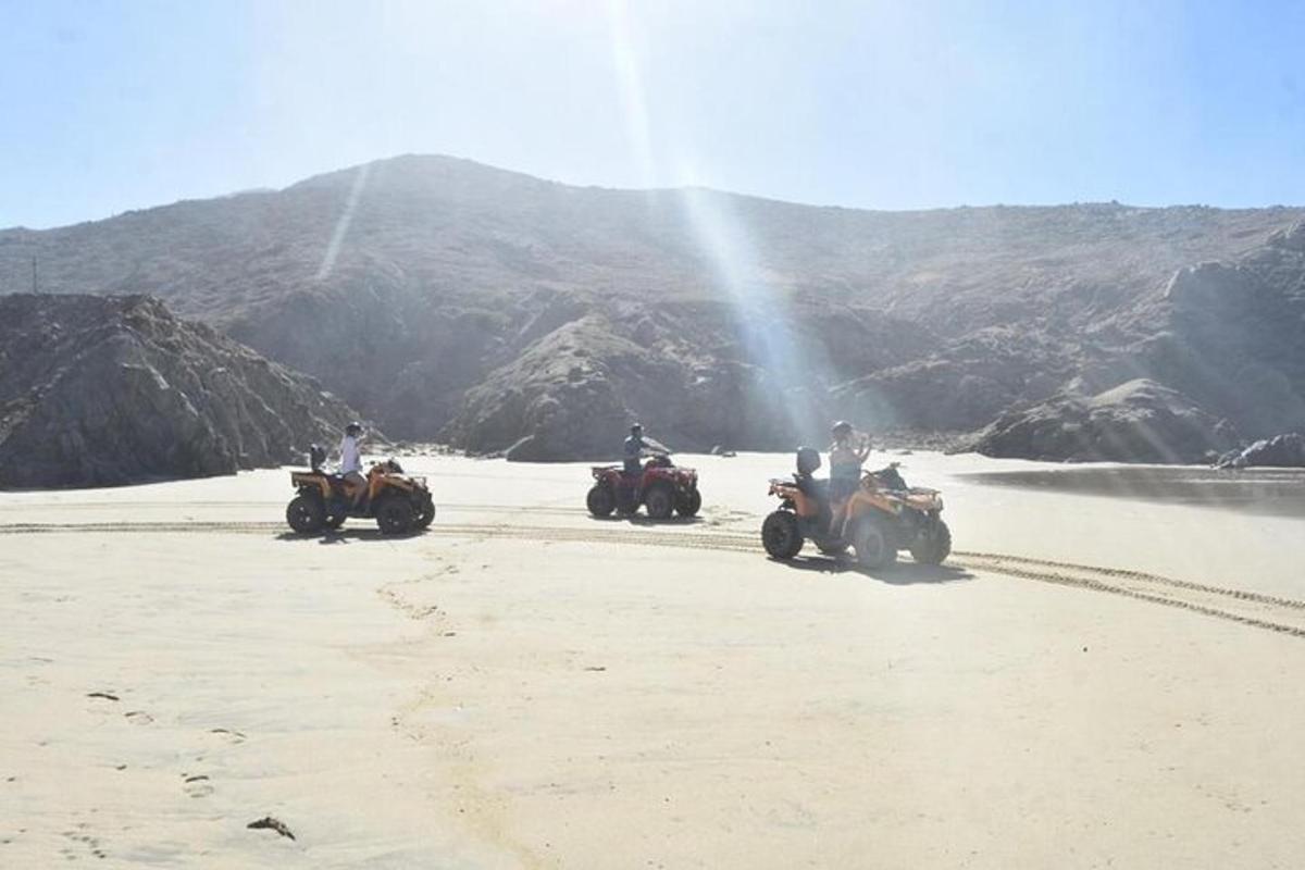 un gruppo di persone in sella a quad sulla spiaggia