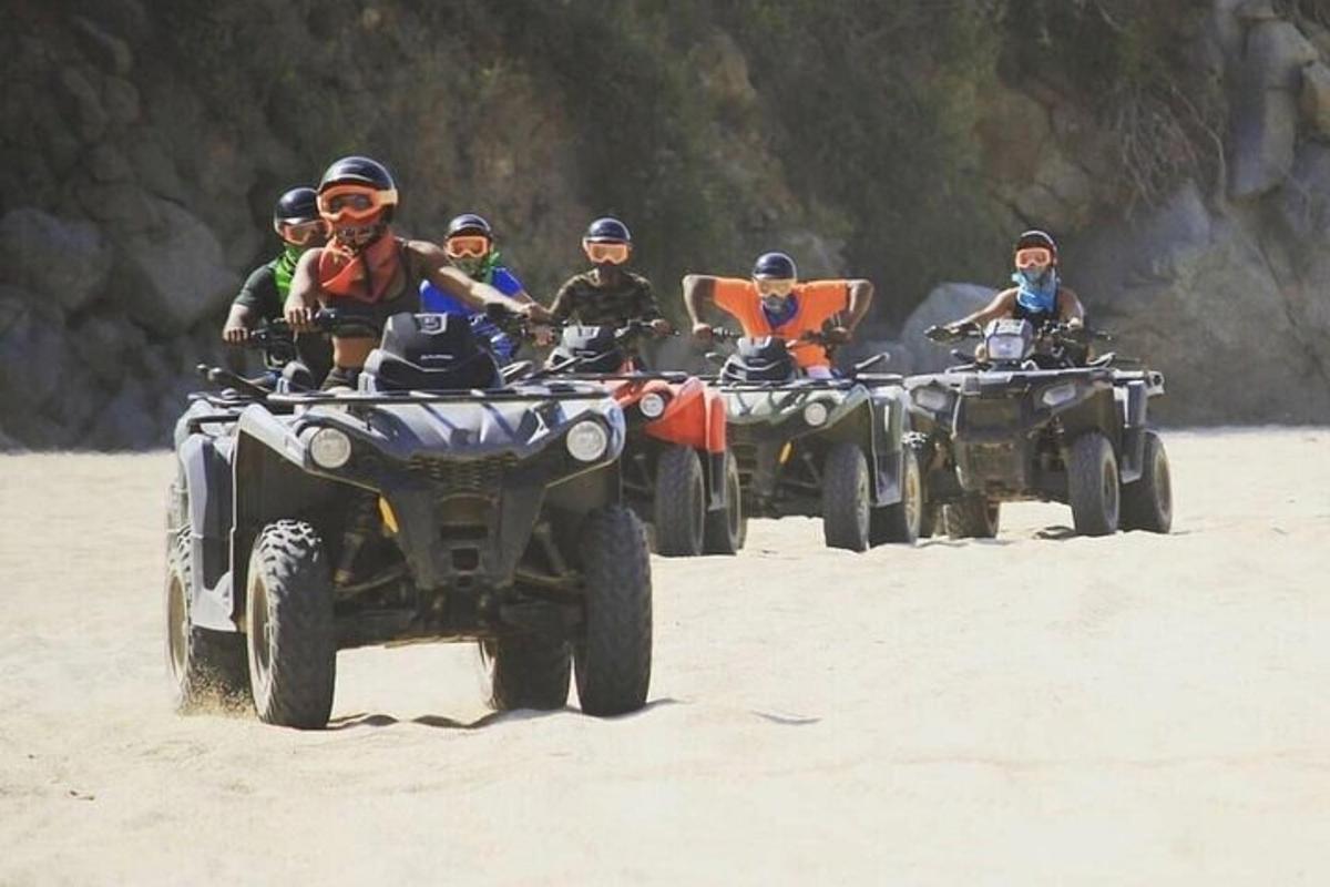 un gruppo di persone in sella a quad sulla spiaggia