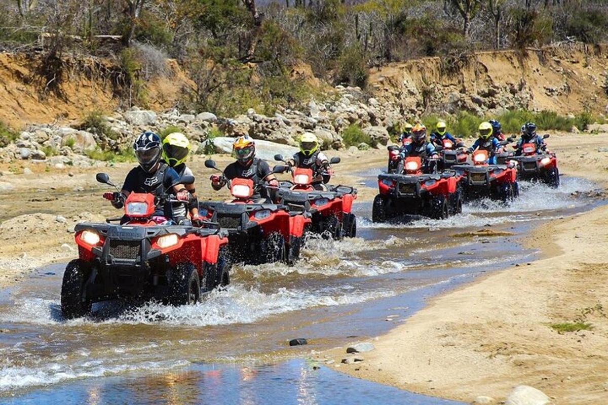 un gruppo di persone su quad che attraversano un fiume