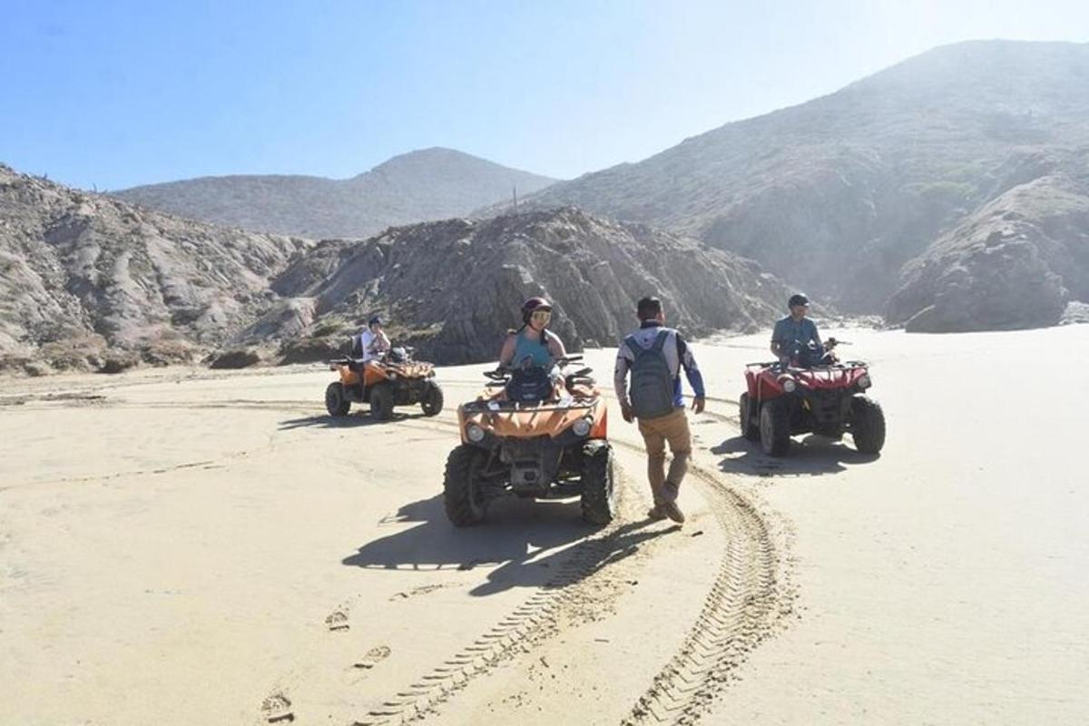 un gruppo di persone che guidano quad nel deserto