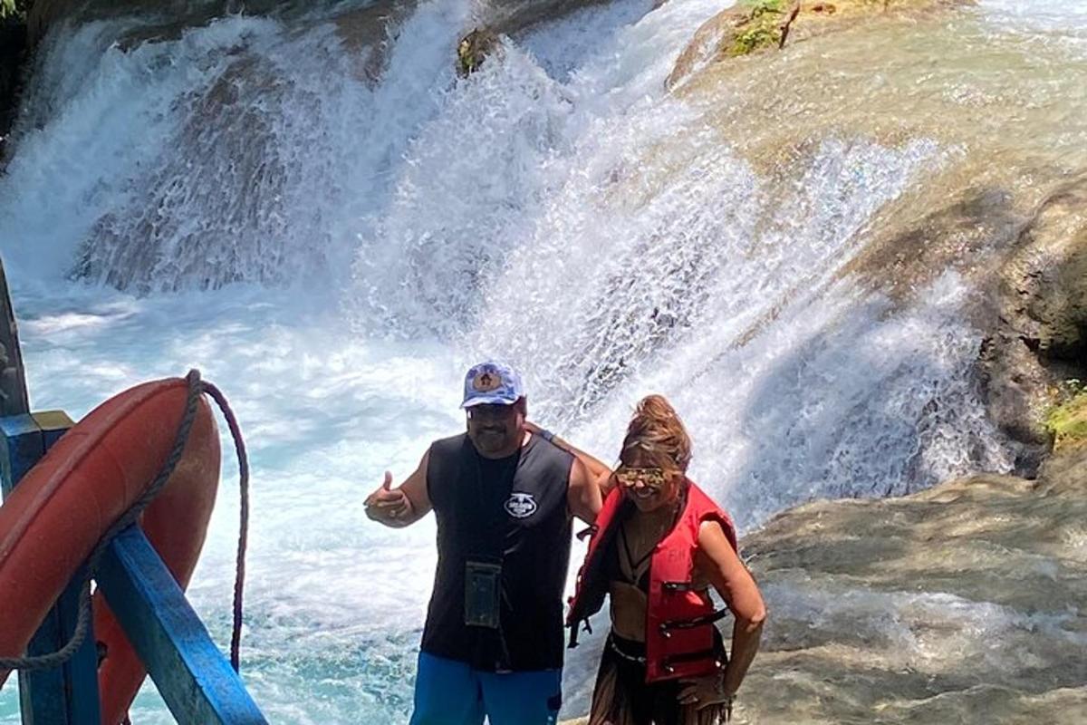 moški in ženska stojita pred slapom