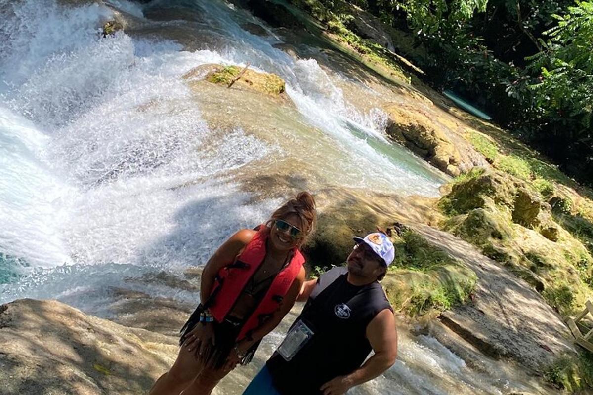 moški in ženska stojita pred slapom