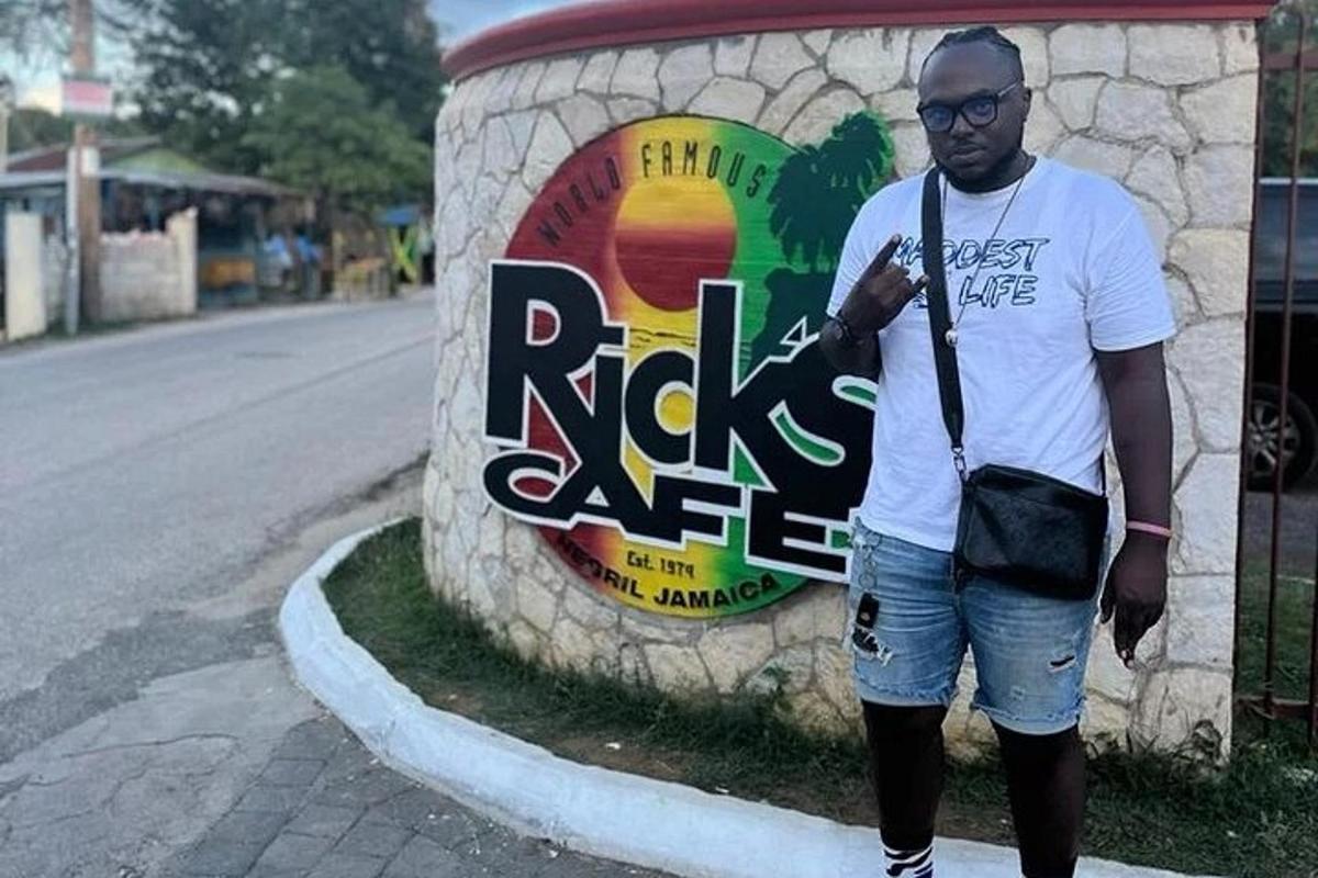 um homem está parado em frente a uma placa