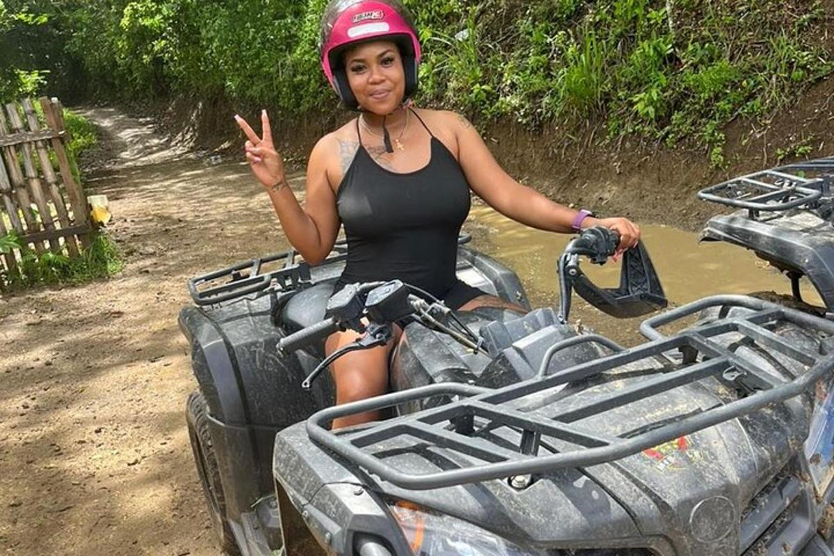 uma mulher sentada em um quadriciclo na lama