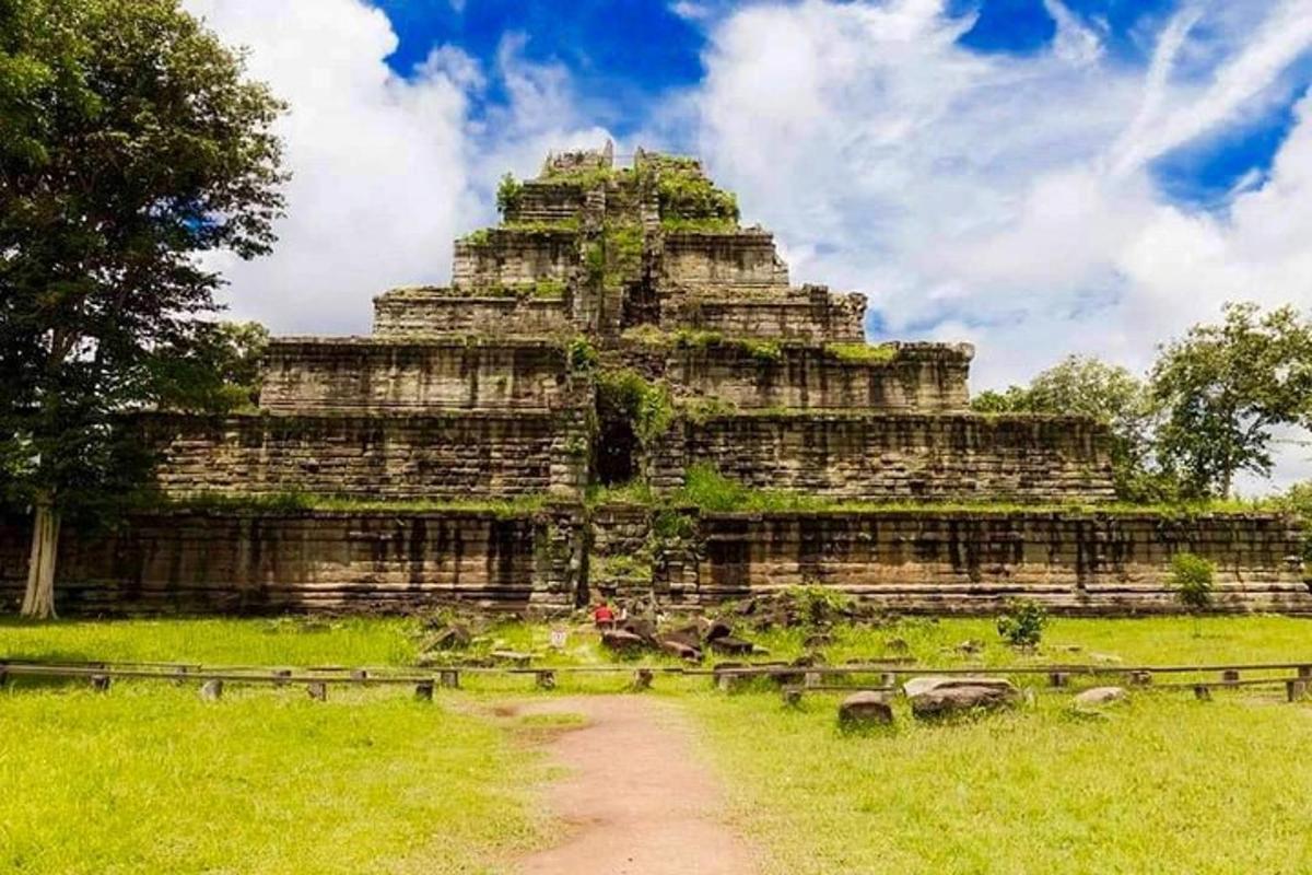 một tòa nhà lớn trên một cánh đồng bên cạnh một con đường đất