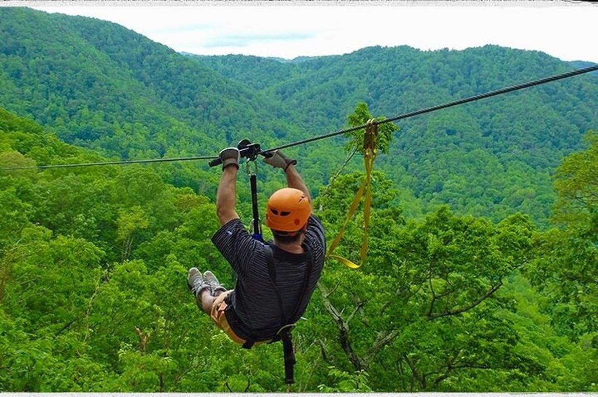 một người đàn ông đang treo mình trên một đường dây zip