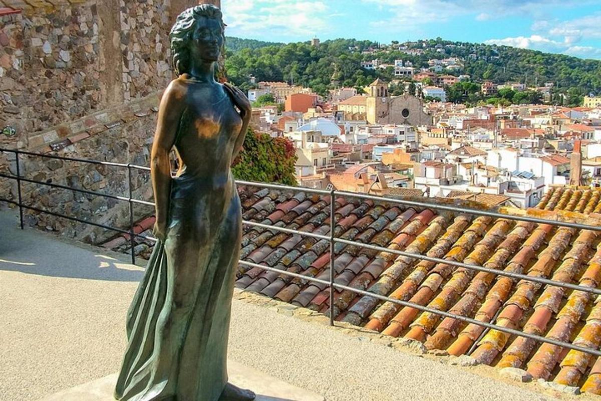 Una estatua de una mujer parada en la cima de una ciudad.