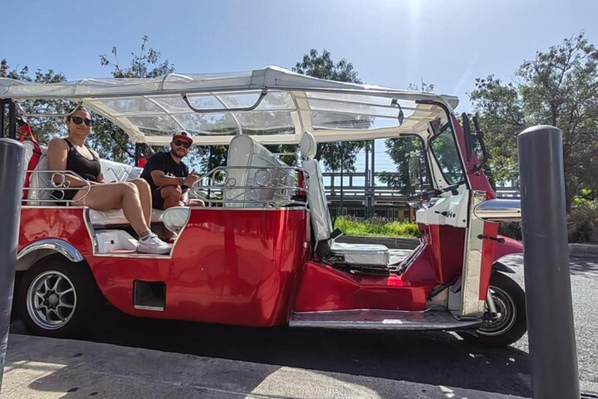 dva lidé jedoucí v červeném golfovém vozíku