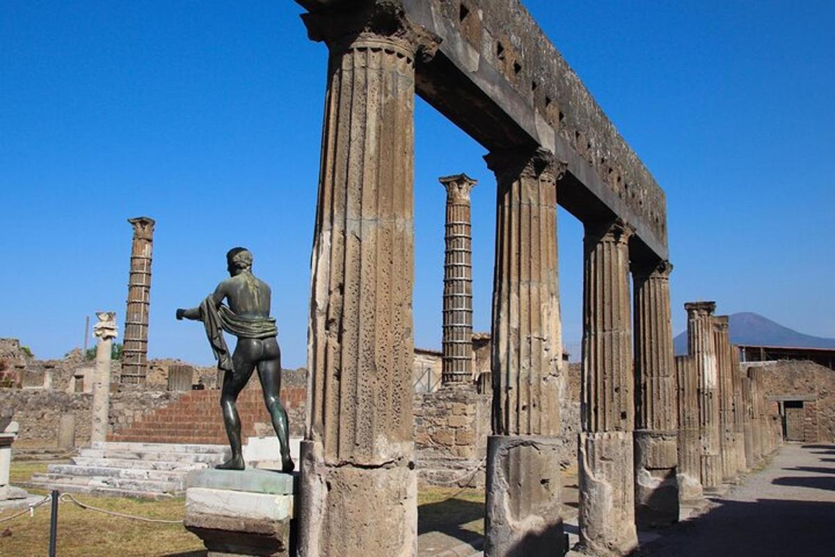 una estàtua d'un home dret al costat d'una columna