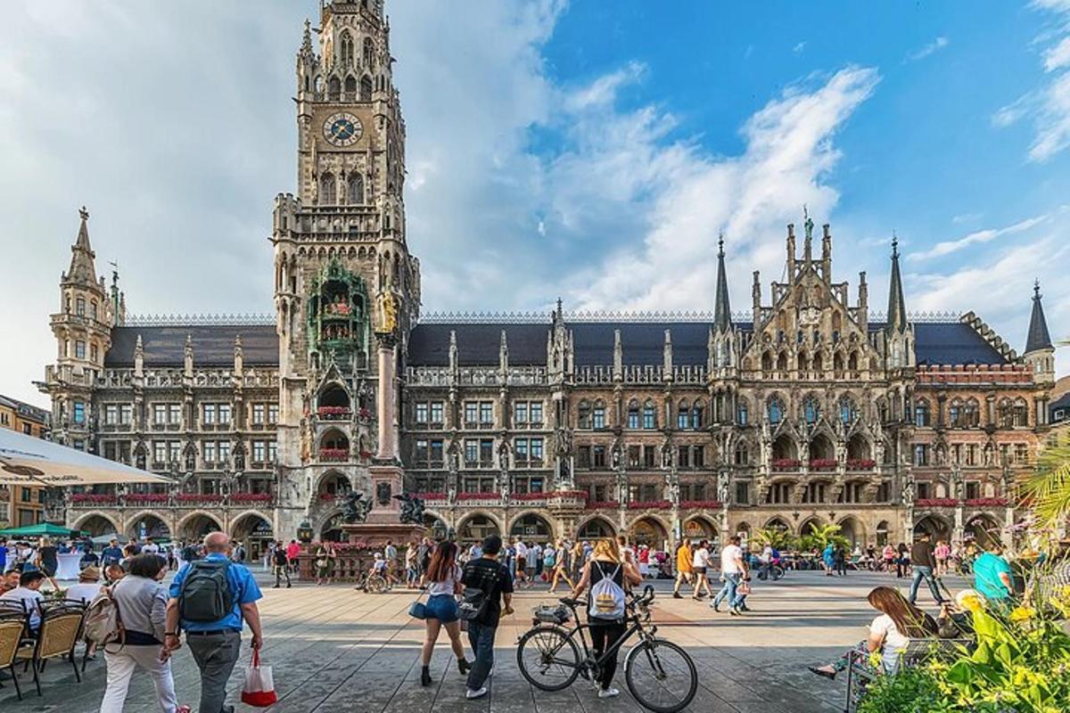 un grande edificio con una torre dell'orologio e persone che camminano intorno ad essa