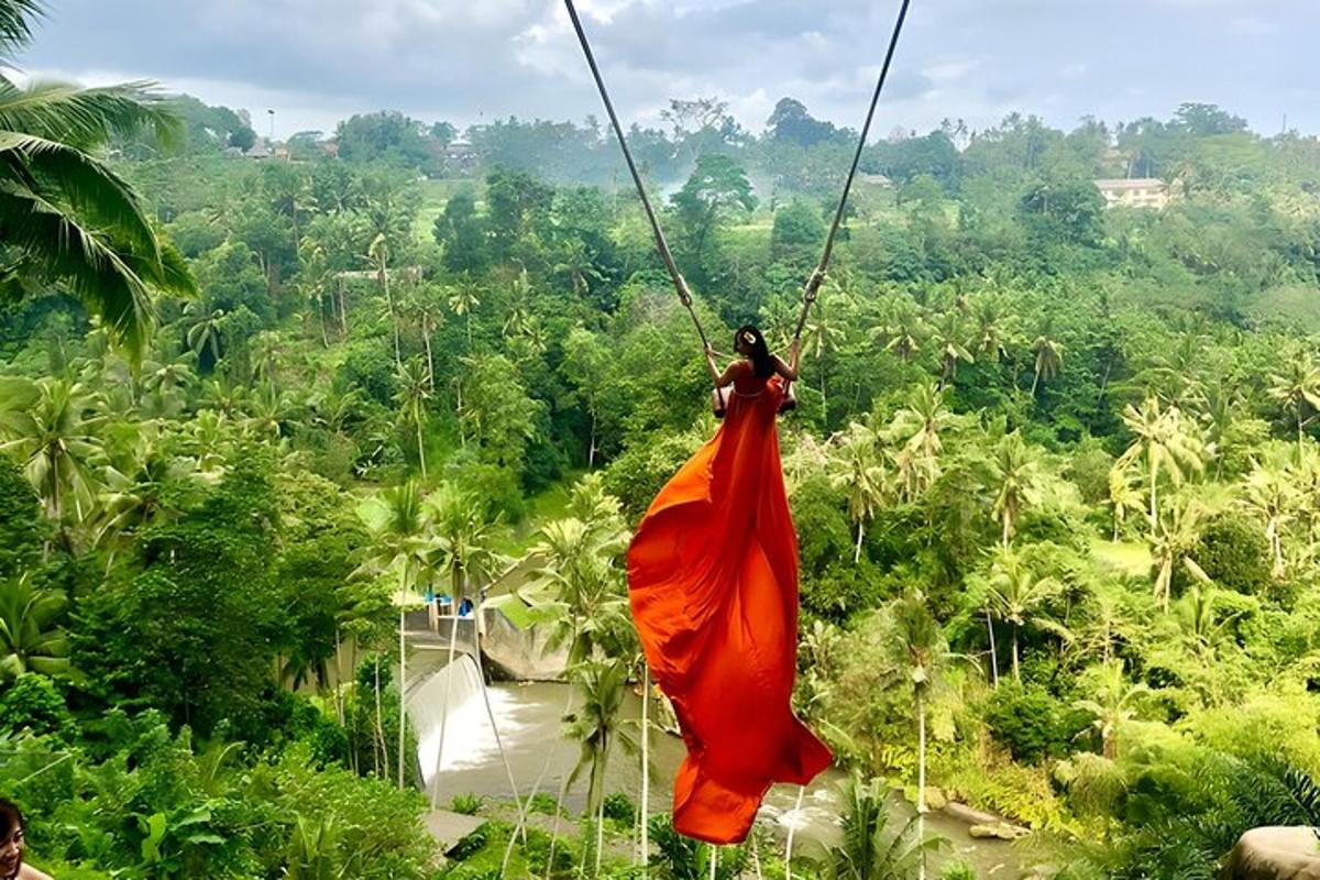 a woman in an orange dress swinging on a zip line