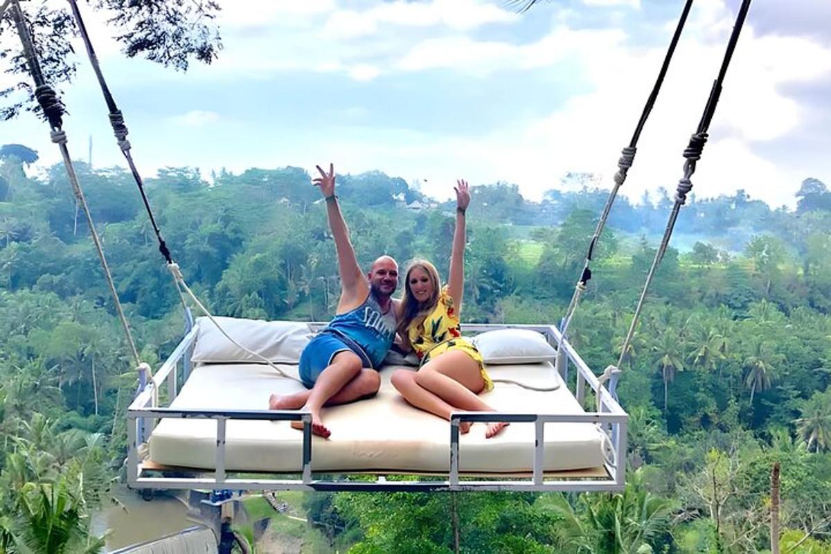 two women sitting on a swing in the jungle