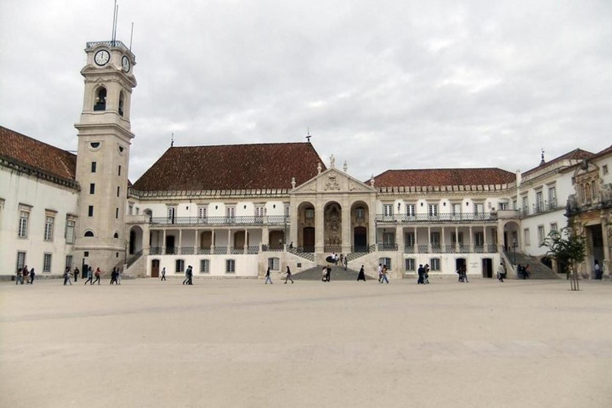 un gran edifici amb una torre de rellotge en un pati