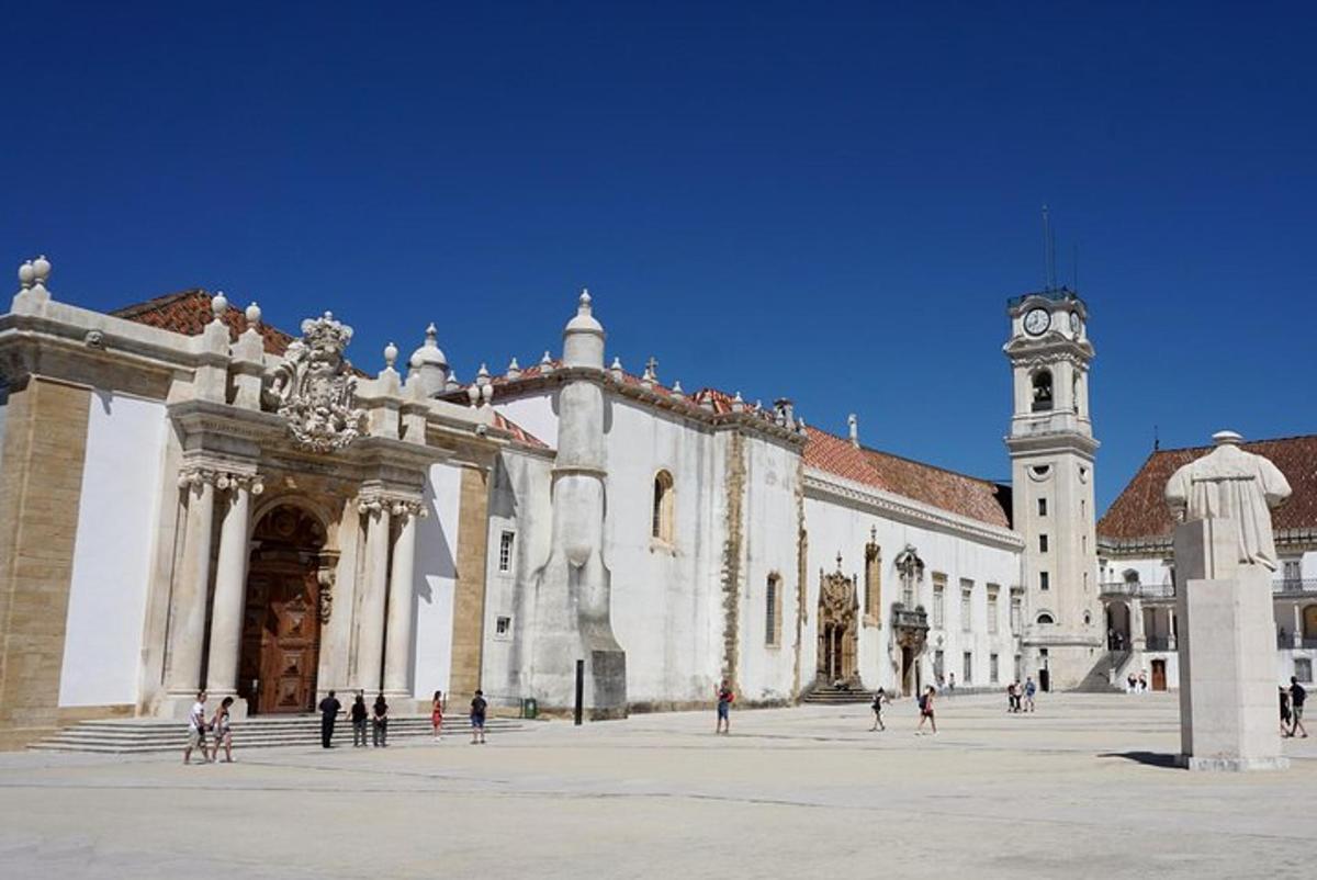 un gran edifici amb una torre de rellotge en un pati
