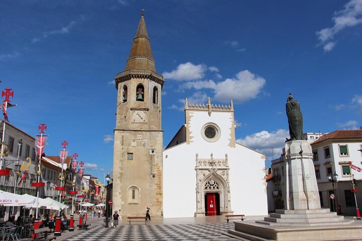 a church with a steeple and a statue in front of it