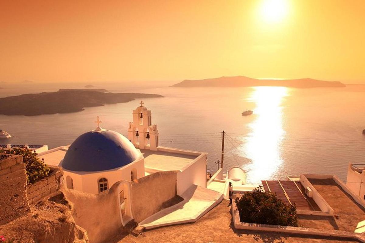 uma vista de uma igreja e do oceano ao pôr do sol
