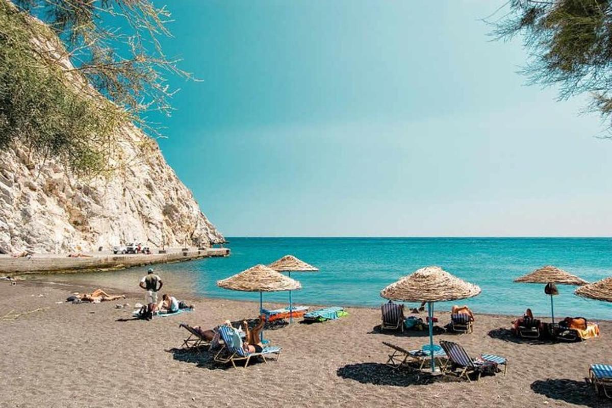 un gruppo di persone sedute su una spiaggia con gli ombrelloni