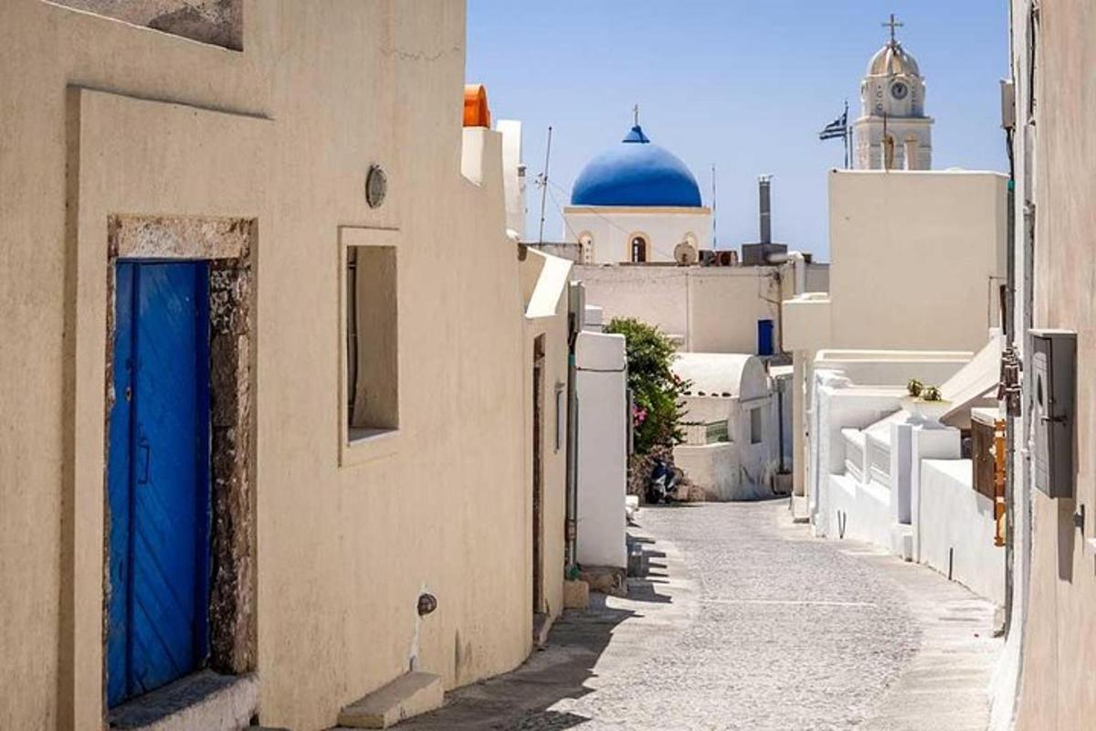 lorong sempit dengan bangunan putih dan pintu biru
