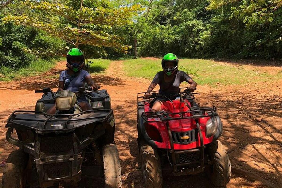 dua orang menaiki atv di jalan tanah