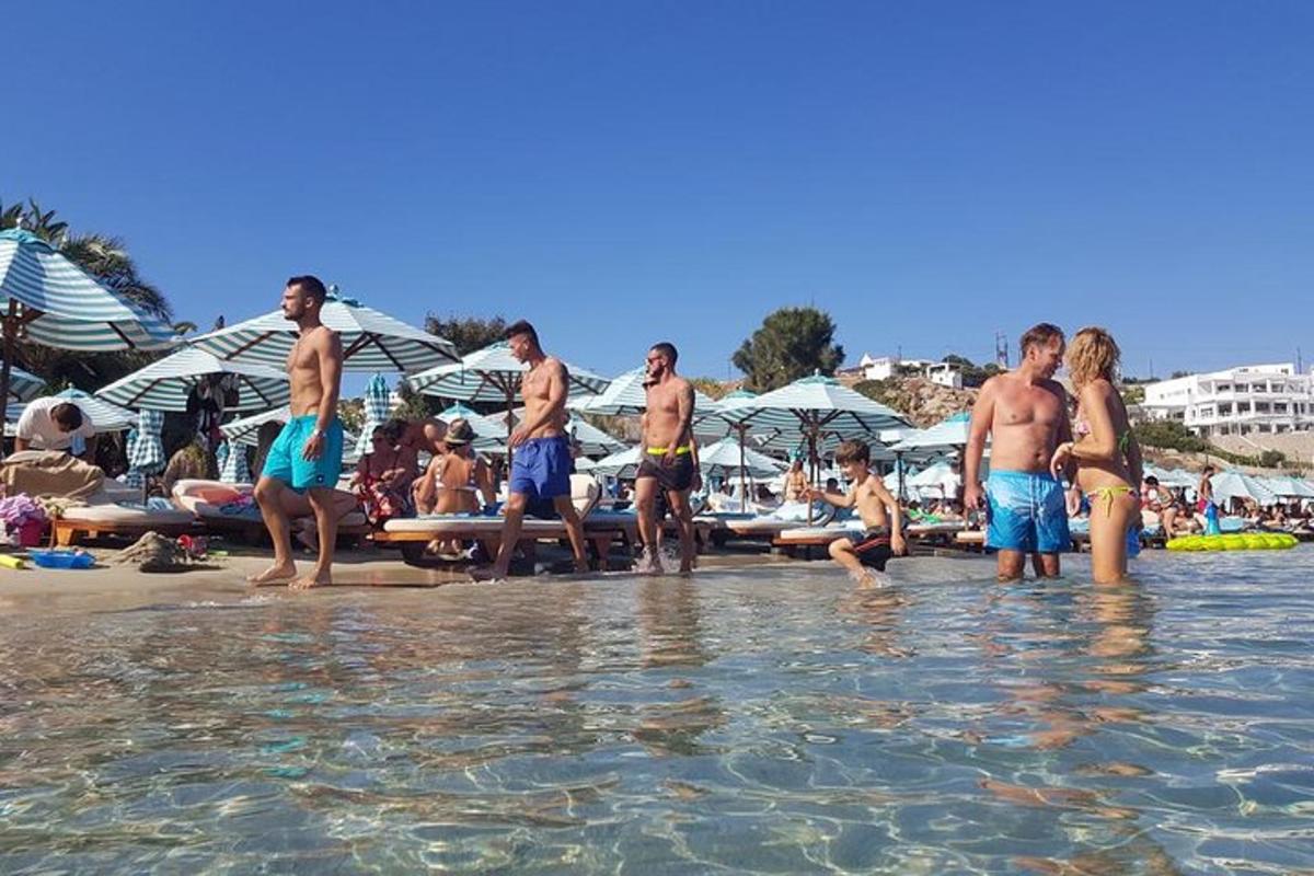 μια ομάδα ανθρώπων που στέκονται στο νερό σε μια παραλία